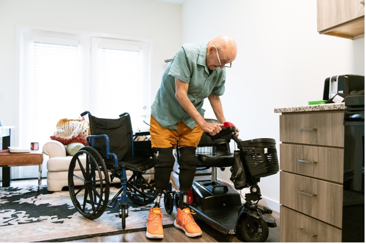 A senior man exploring a mobility scooter and a wheelchair.