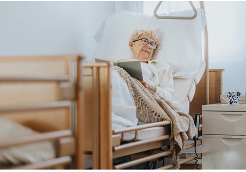 An older woman lying on a hospital bed | Modern Mobility Solutions